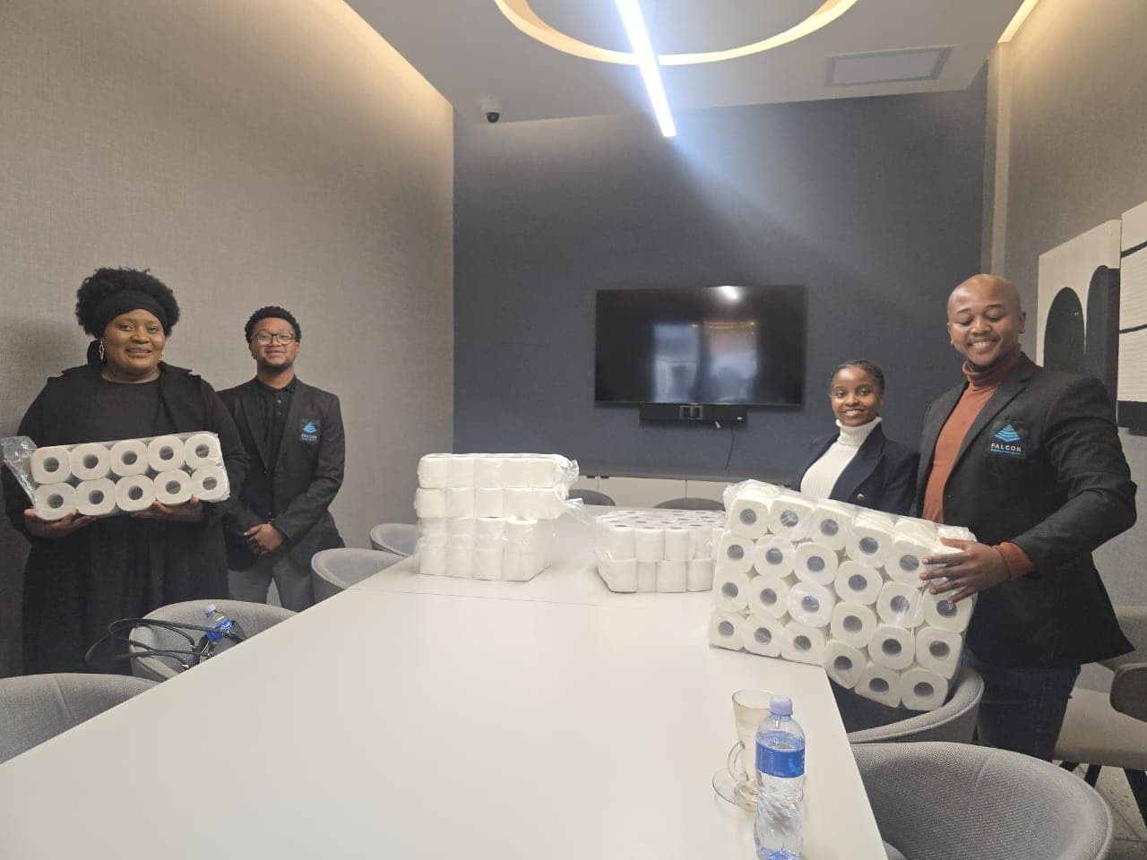 People in a meeting room with packed supplies on a table