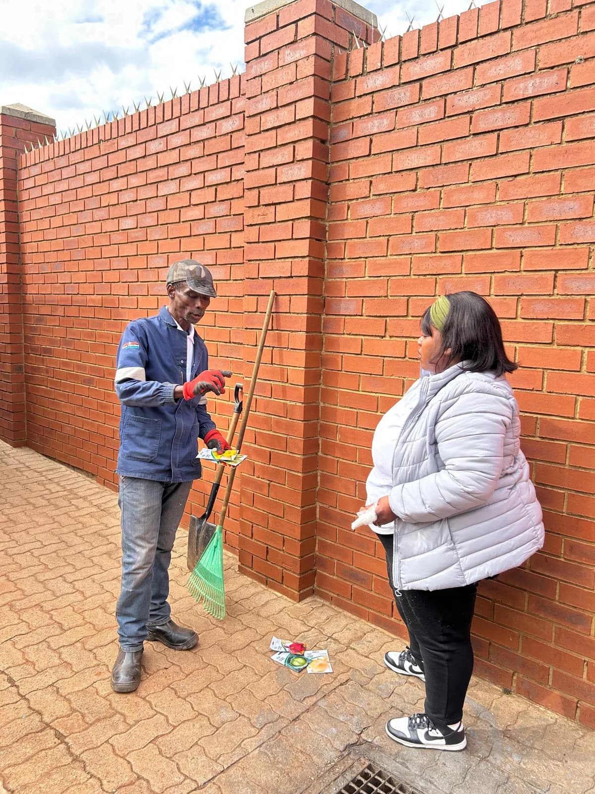 People coordinating outside near a brick boundary wall