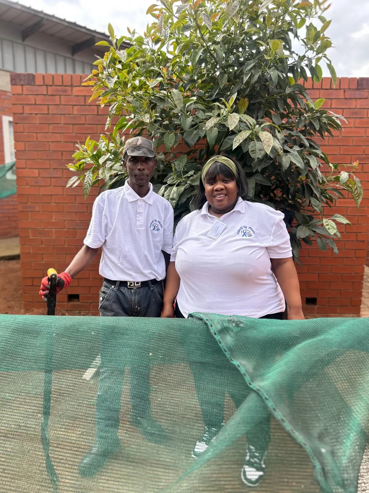 People standing near outdoor landscaping and boundary wall work