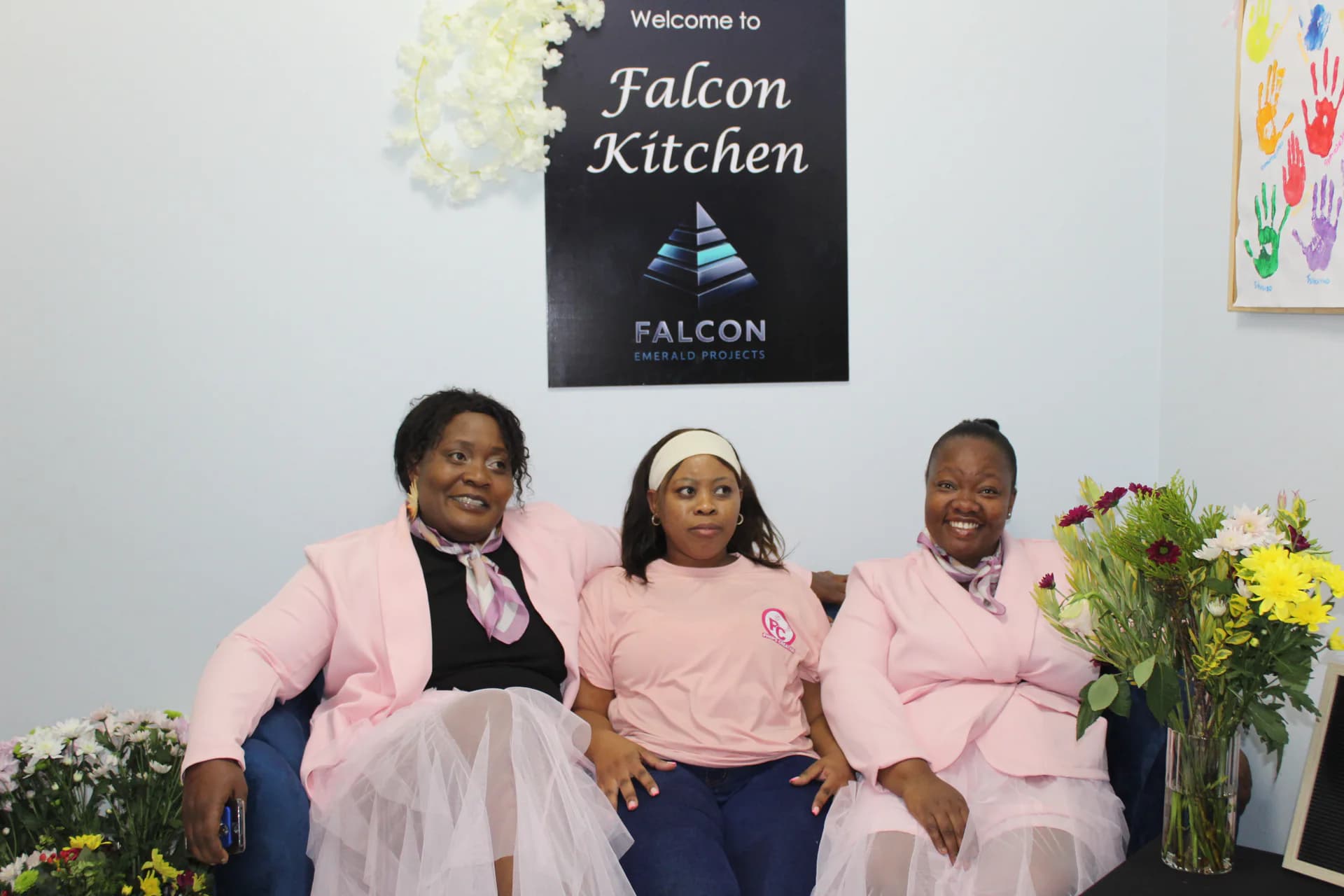 Falcon Kitchen team members seated together in a decorated service area