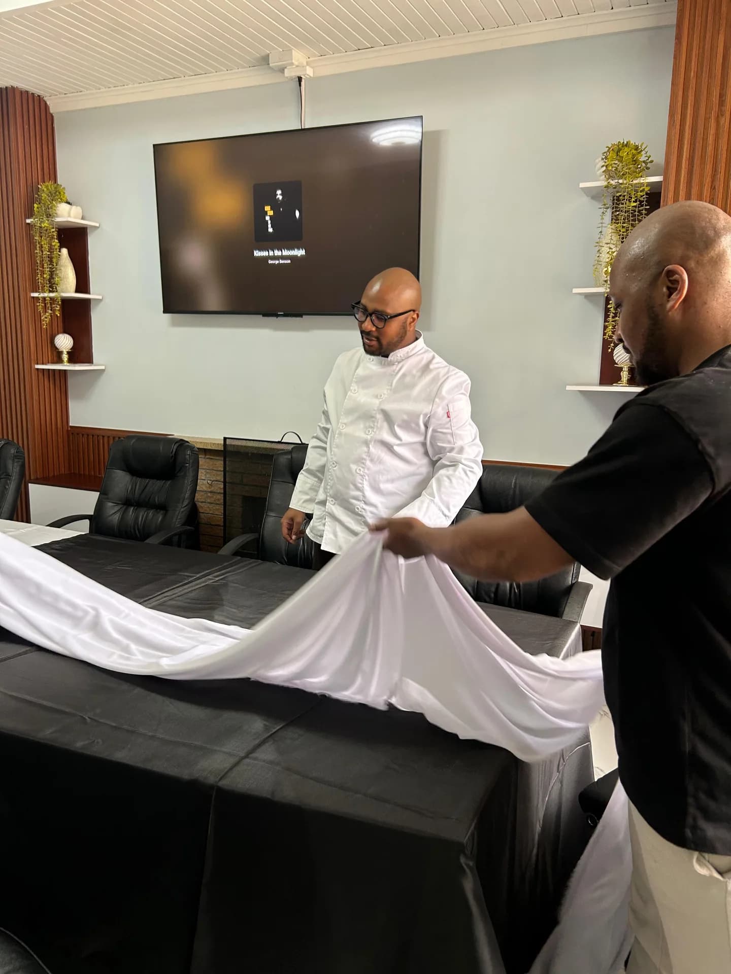 Chef and event team member arranging table linen before service