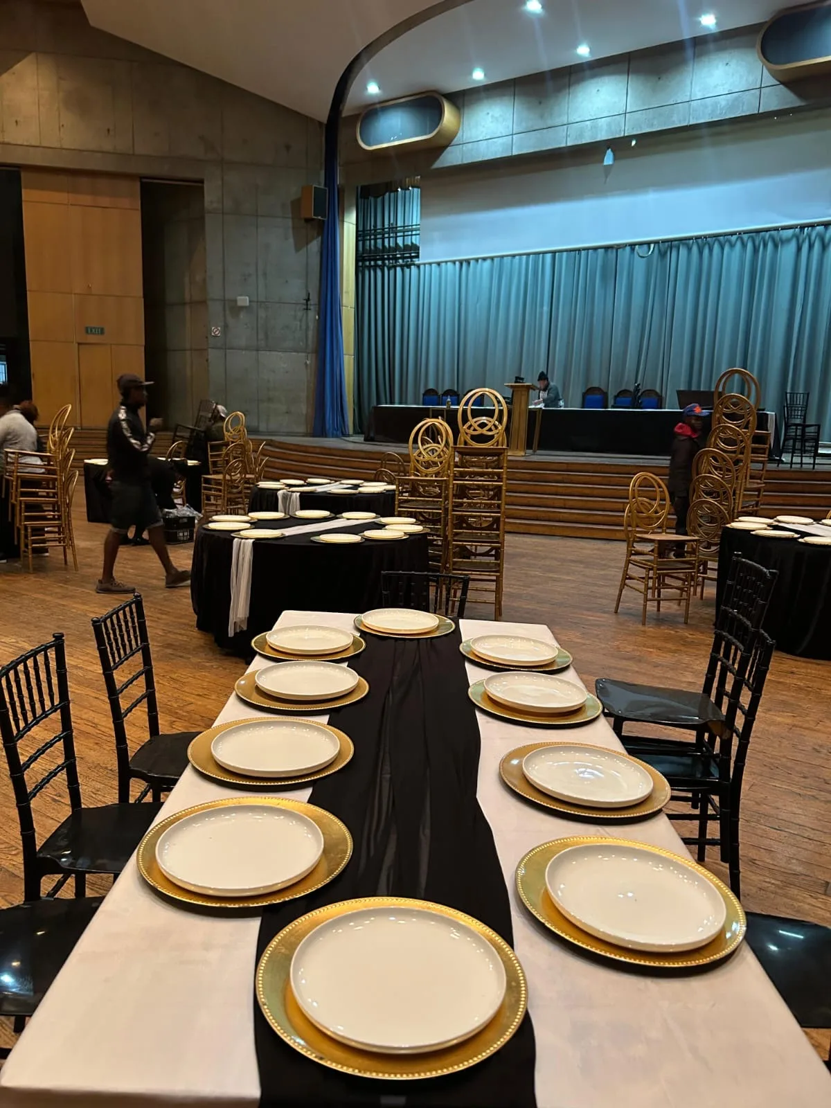 Falcon Kitchen event tables arranged with black and white linen and gold place settings