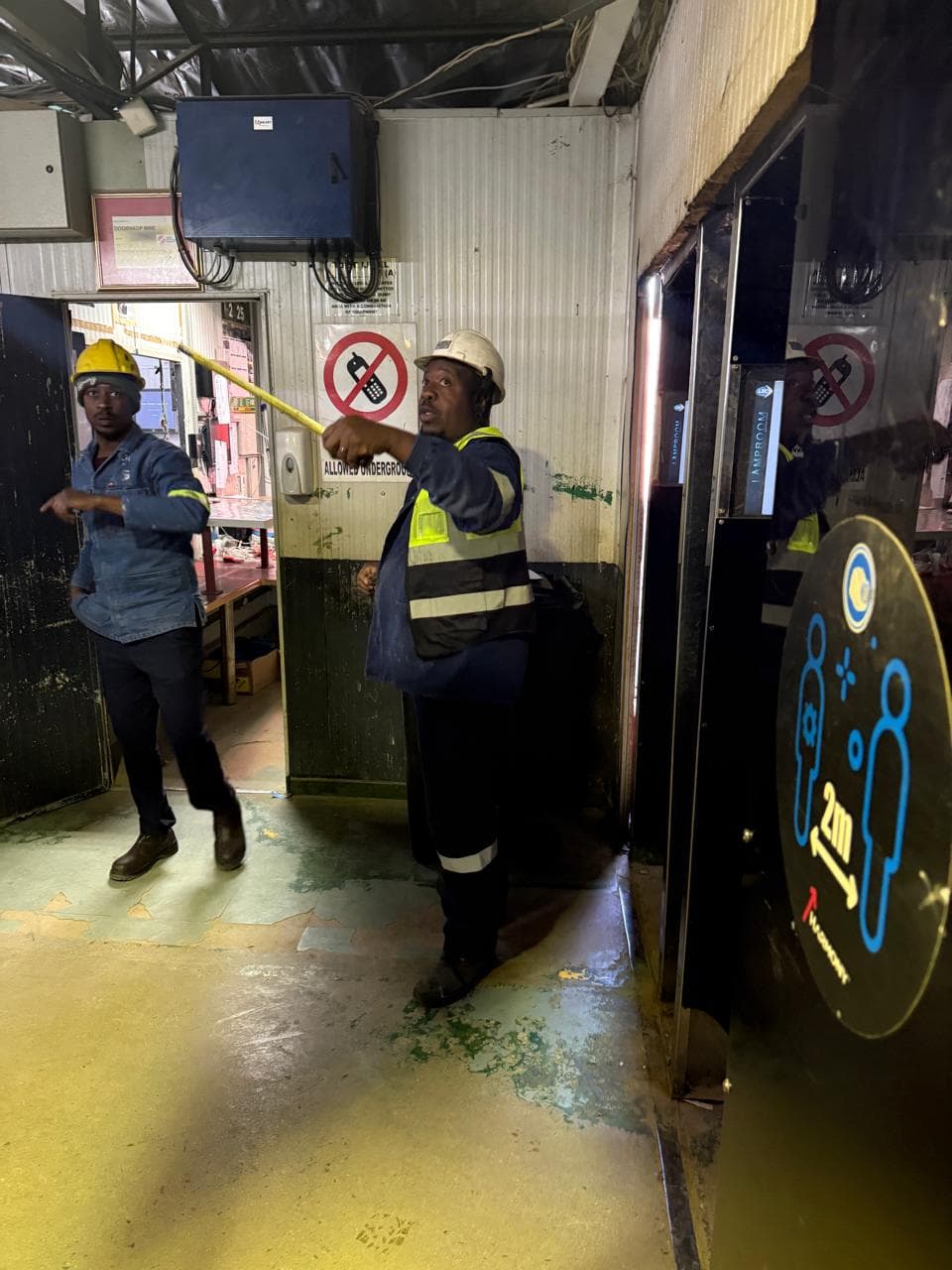 Security technicians working near access control equipment at an industrial entrance