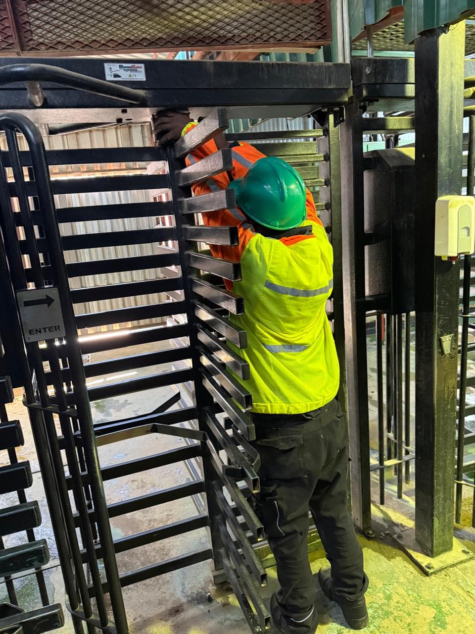 Technician working on turnstile equipment inside a facility