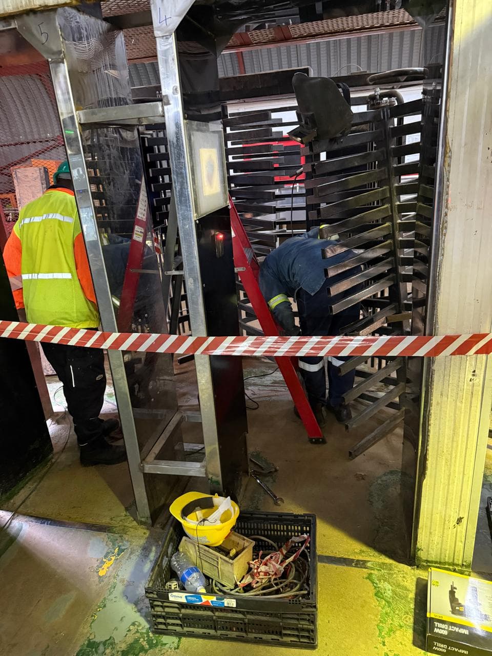 Workers and equipment around a controlled-entry installation area