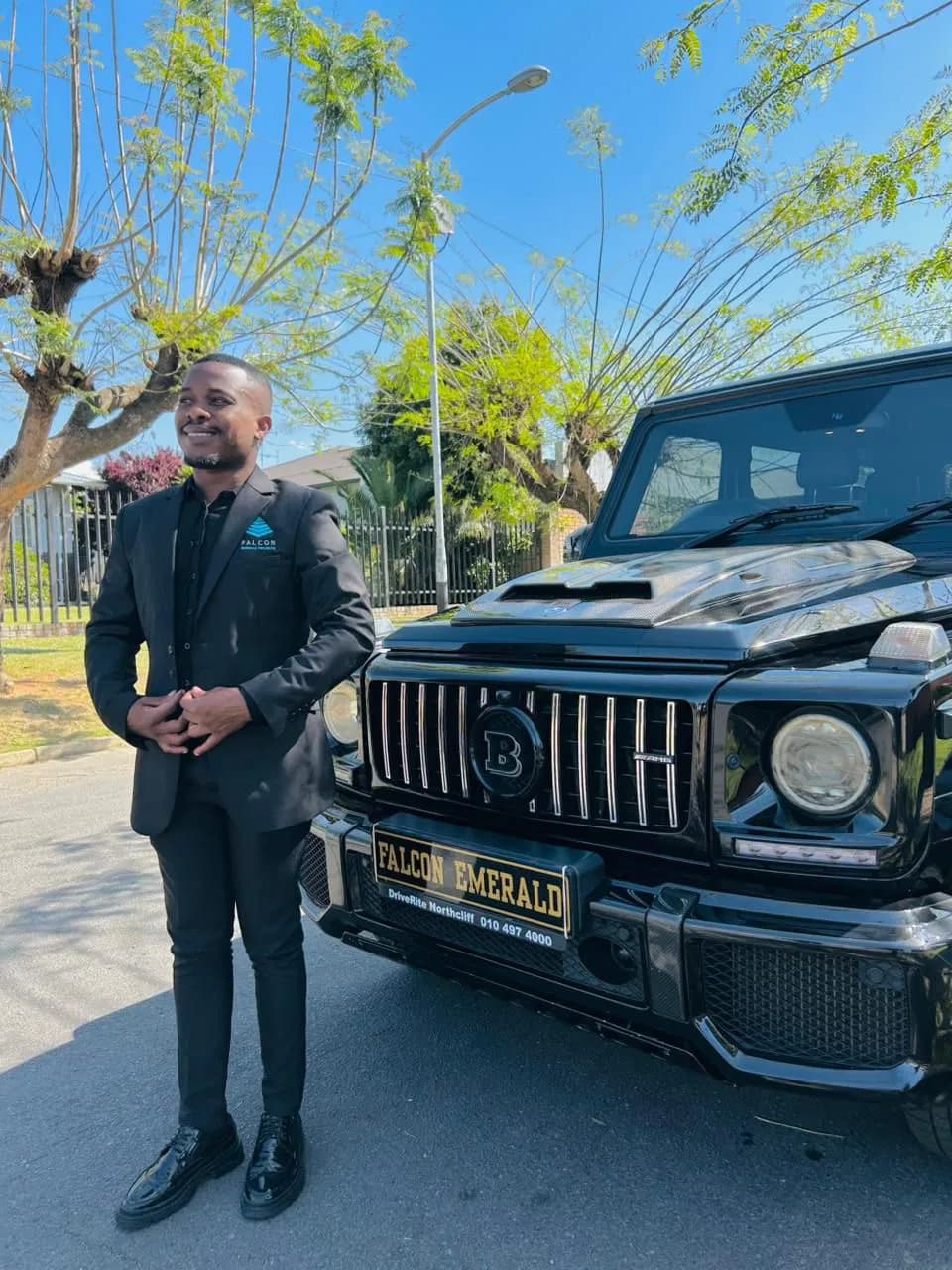 Driver standing beside a black tour vehicle