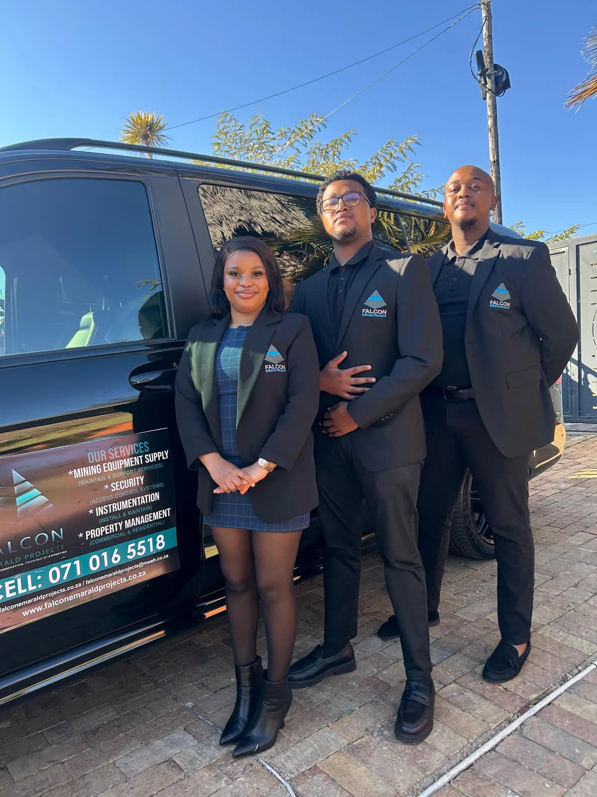 Falcon Emerald shuttle services team standing beside a branded vehicle