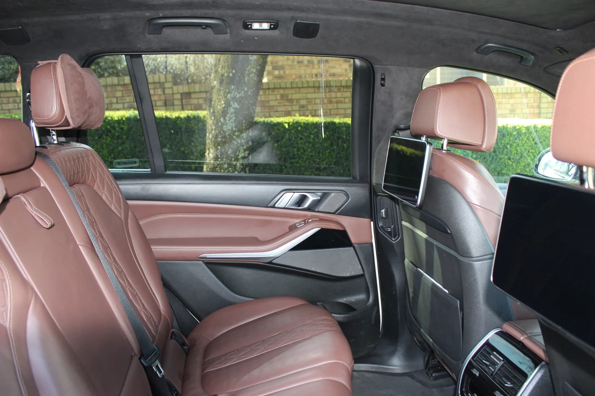 BMW X7 rear passenger cabin with leather seating and passenger screens